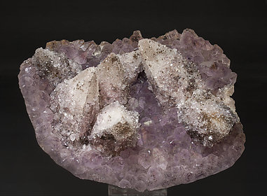 Calcite on Quartz (variety amethyst) and Hematite. 