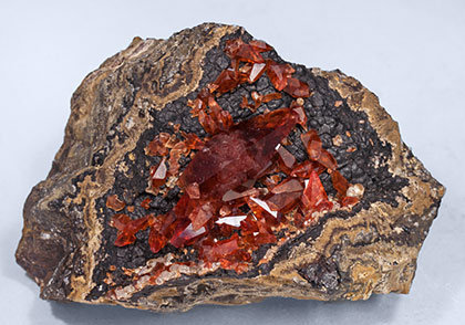 Rhodochrosite with manganese oxides.