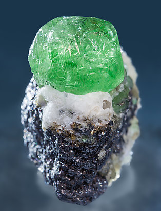 Grossular (variety tsavorite) with Pyrite and Graphite. Light behind