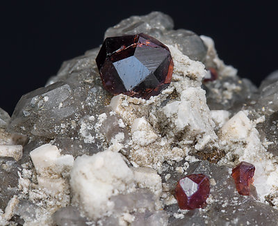 Almandine-Spessartine (Series) with Orthoclase and Quartz (variety smoky). 