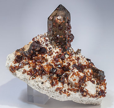 Spessartine with Quartz (variety smoky) and Feldspar.