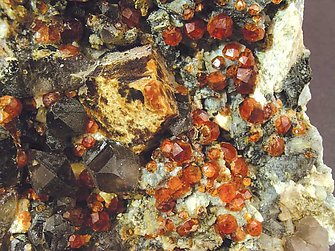 Helvine with Spessartine, smoky Quartz and Feldspar. 