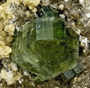 Fluorapatite with Siderite, Arsenopyrite, Pyrite, Ferberite, Schorl-Dravite and Muscovite. 