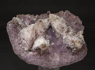 Calcite on Quartz (variety amethyst) and Hematite.